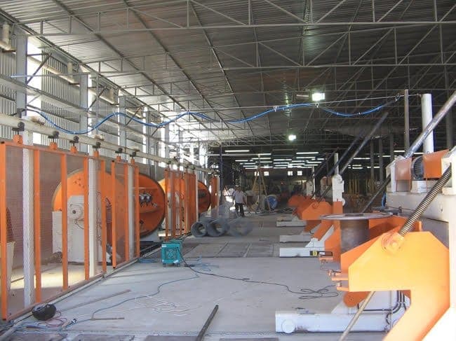 Galpão industrial com máquinas de cabos instaladas sobre as bases executadas.