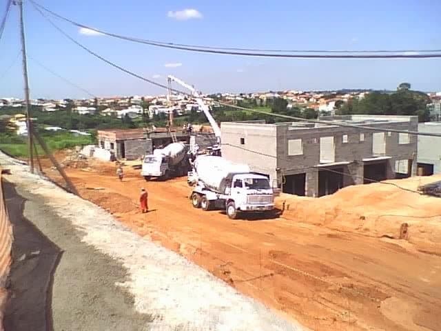 Canteiro de obra do condomínio com caminhão betoneira e bomba de concreto.