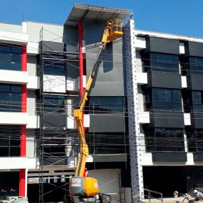 Plataforma elevatória trabalhando na fachada de edifício em retrofit.